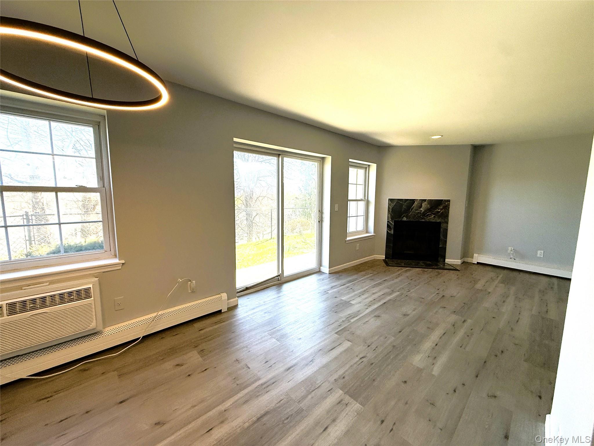 25 Lexington Hills Road, Unit 8 Harriman, NY 10926 - Photo 8 of 24 an empty room with wooden floor and windows