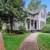 a front view of a house with a yard and potted plants