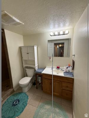 641 East Greystone Way Tooele, UT 84074 - Photo 17 of 30 Bathroom featuring a single vanity with wood-finish cabinetry, a white countertop, and a built-in sink