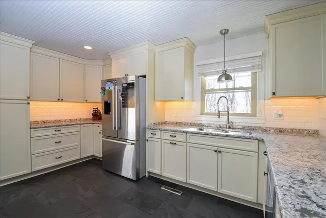 a kitchen with stainless steel appliances granite countertop a sink and a stove