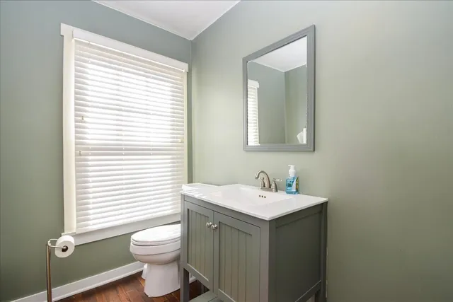 a view of an empty room with wooden floor fireplace and a window