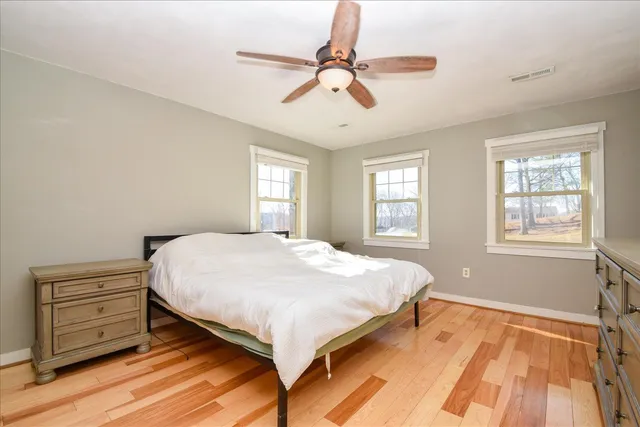 a bedroom with a bed a dresser and a chandelier