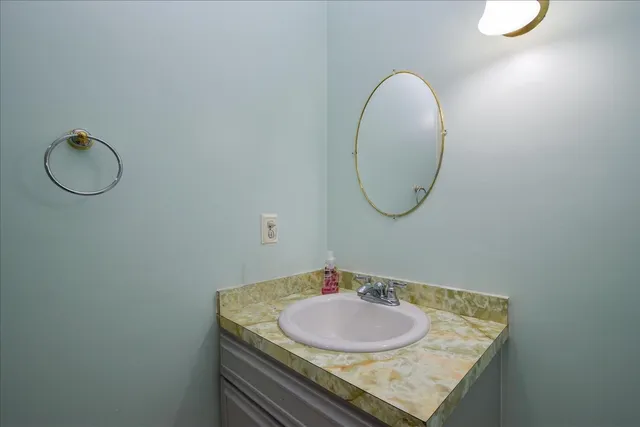 a bathroom with a granite countertop sink a mirror and a bathtub
