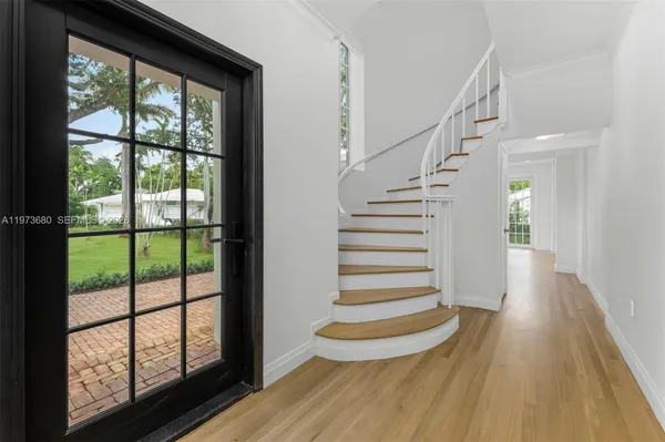 a view of entryway with wooden floor and front door