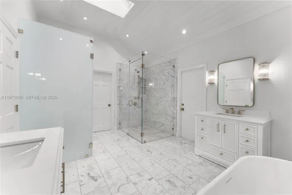 a bathroom with a granite countertop sink a toilet a mirror and shower