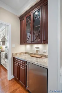 a kitchen with granite countertop wood cabinets and a wooden floor