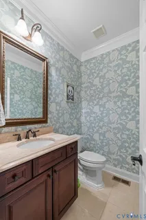 a bathroom with a granite countertop toilet a sink and a mirror