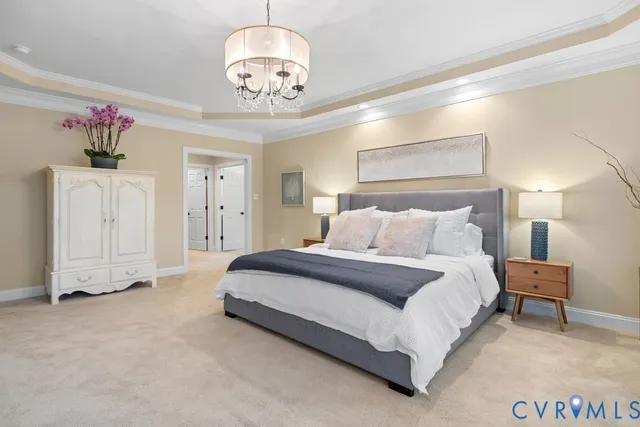 a spacious bedroom with a bed and a chandelier