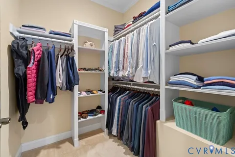 a view of walk in closet with clothes and shoes
