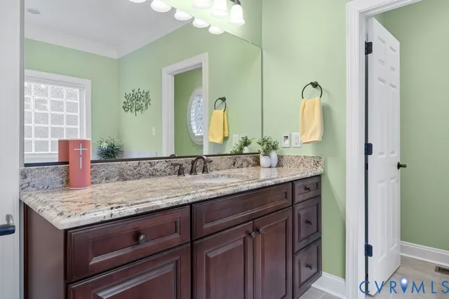 a bathroom with a granite countertop sink and a mirror