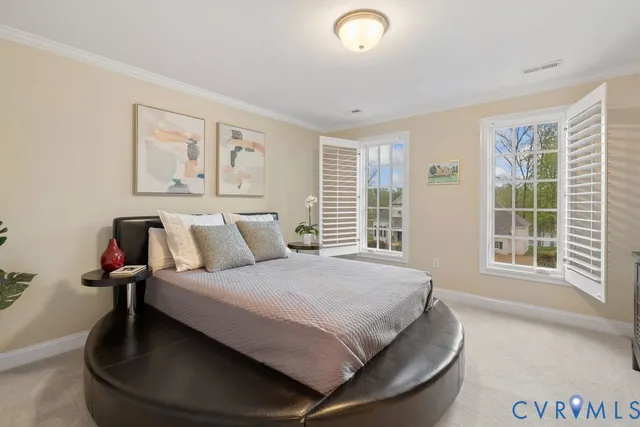 a large bedroom with a bed and wooden floor