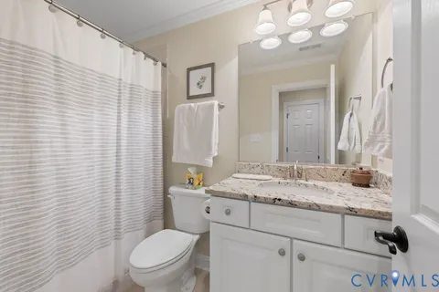 a bathroom with a granite countertop toilet sink and mirror