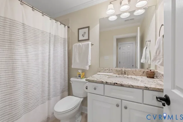 a bathroom with a granite countertop toilet sink and mirror