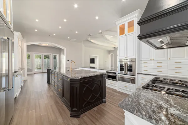 a kitchen with stainless steel appliances granite countertop a stove and a wooden floors