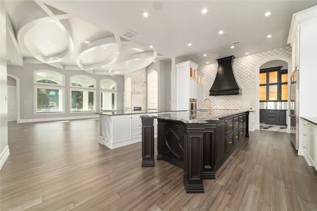 an open kitchen with granite countertop a stove and a wooden floors