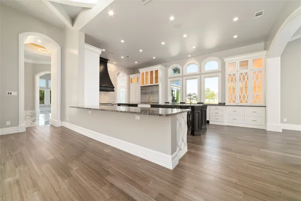 an open kitchen with granite countertop a stove and a wooden floors
