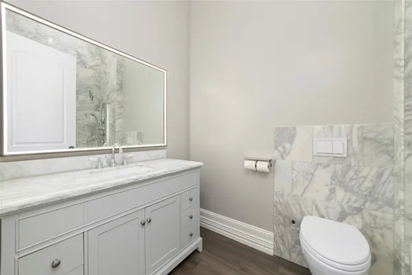 a bathroom with a granite countertop sink a toilet and a mirror