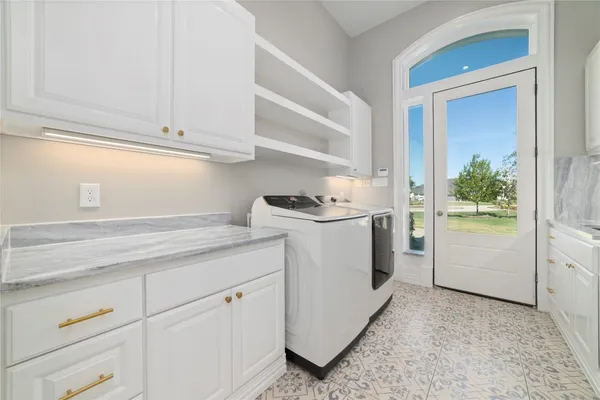 a utility room with cabinets washer and dryer