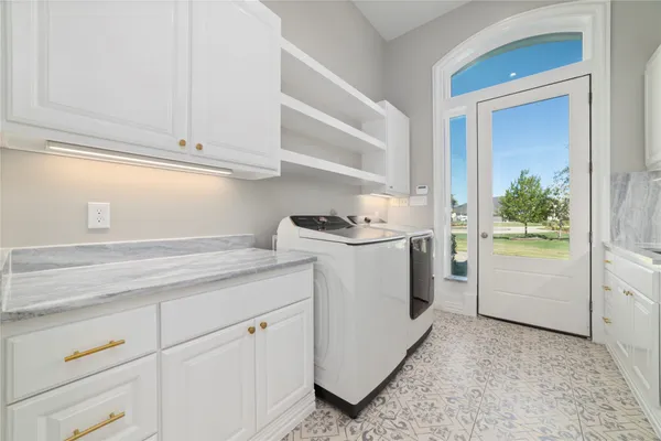 a utility room with cabinets washer and dryer