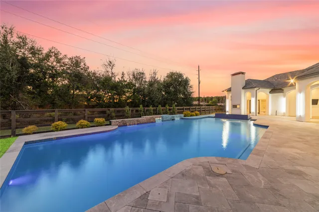 a view of a swimming pool that has lawn chairs with wooden floor