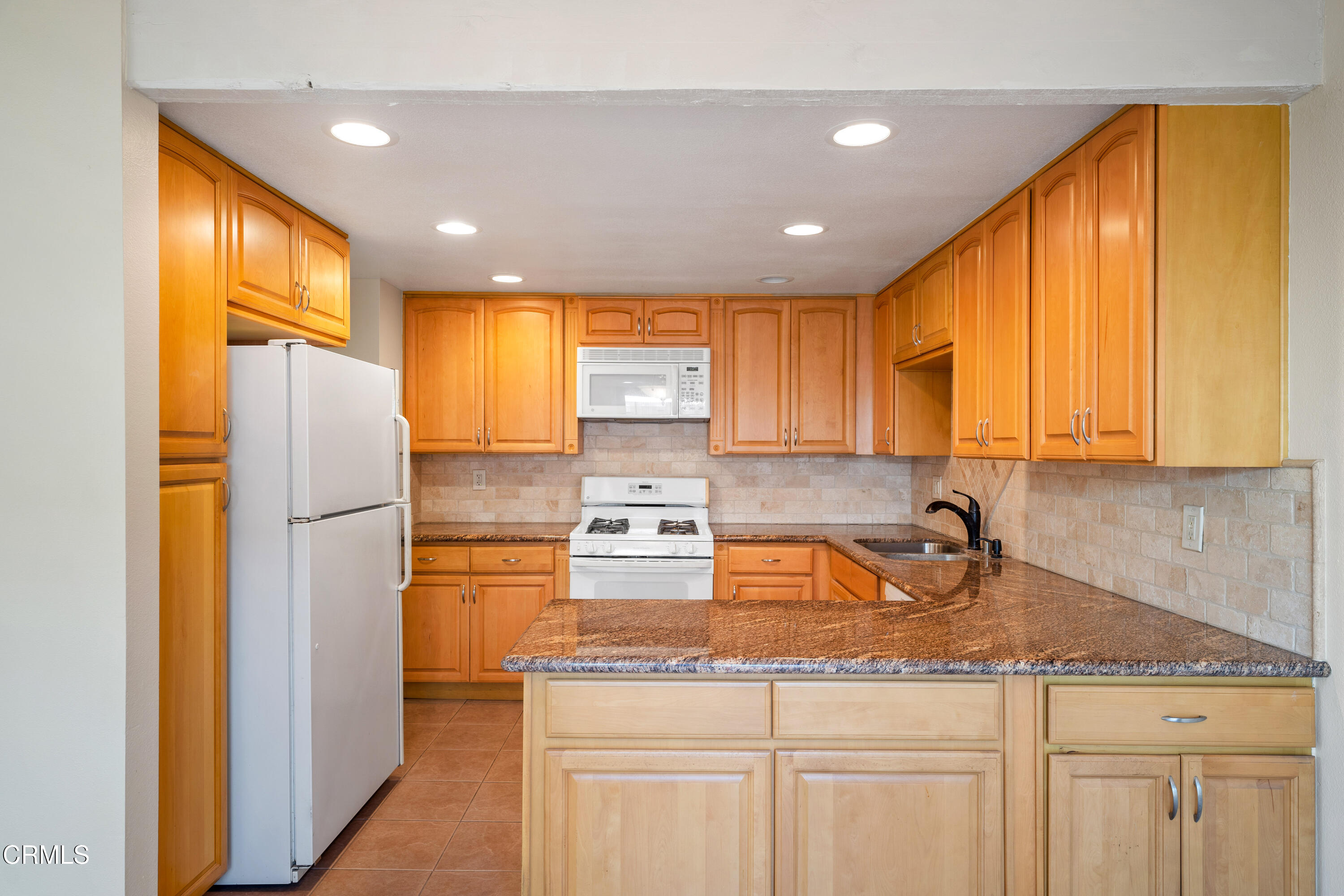 500 Holly Avenue Oxnard, CA 93036 - Photo 13 of 33 a kitchen with stainless steel appliances granite countertop a sink a refrigerator and cabinets