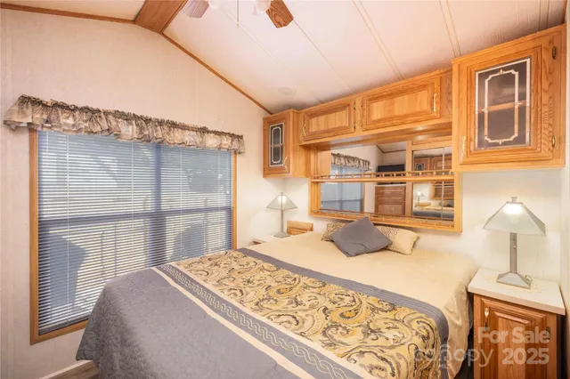 a bedroom with a bed and a flat tv screen on the dresser