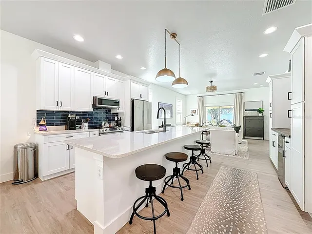 a kitchen with stainless steel appliances granite countertop a refrigerator sink stove microwave and cabinets