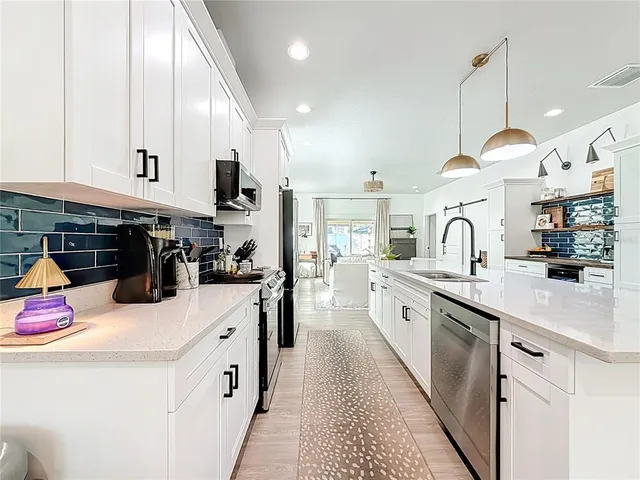 a kitchen with stainless steel appliances granite countertop a sink and cabinets