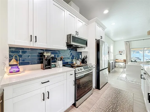 a large kitchen with stainless steel appliances lots of counter space and a sink