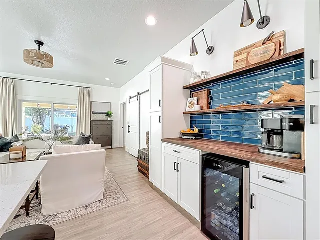 a kitchen with white cabinets and sink