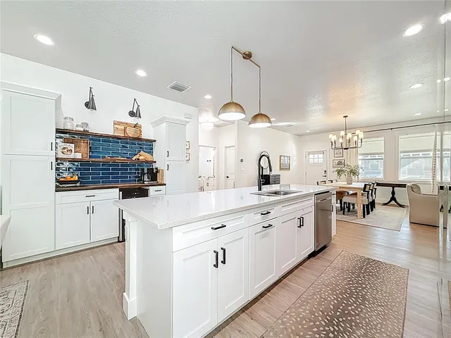 a kitchen with stainless steel appliances granite countertop a refrigerator and a stove top oven