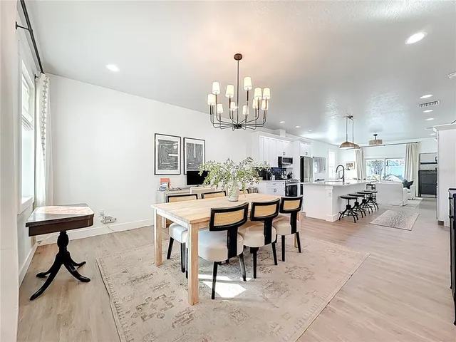 a view of a dining room with furniture and chandelier