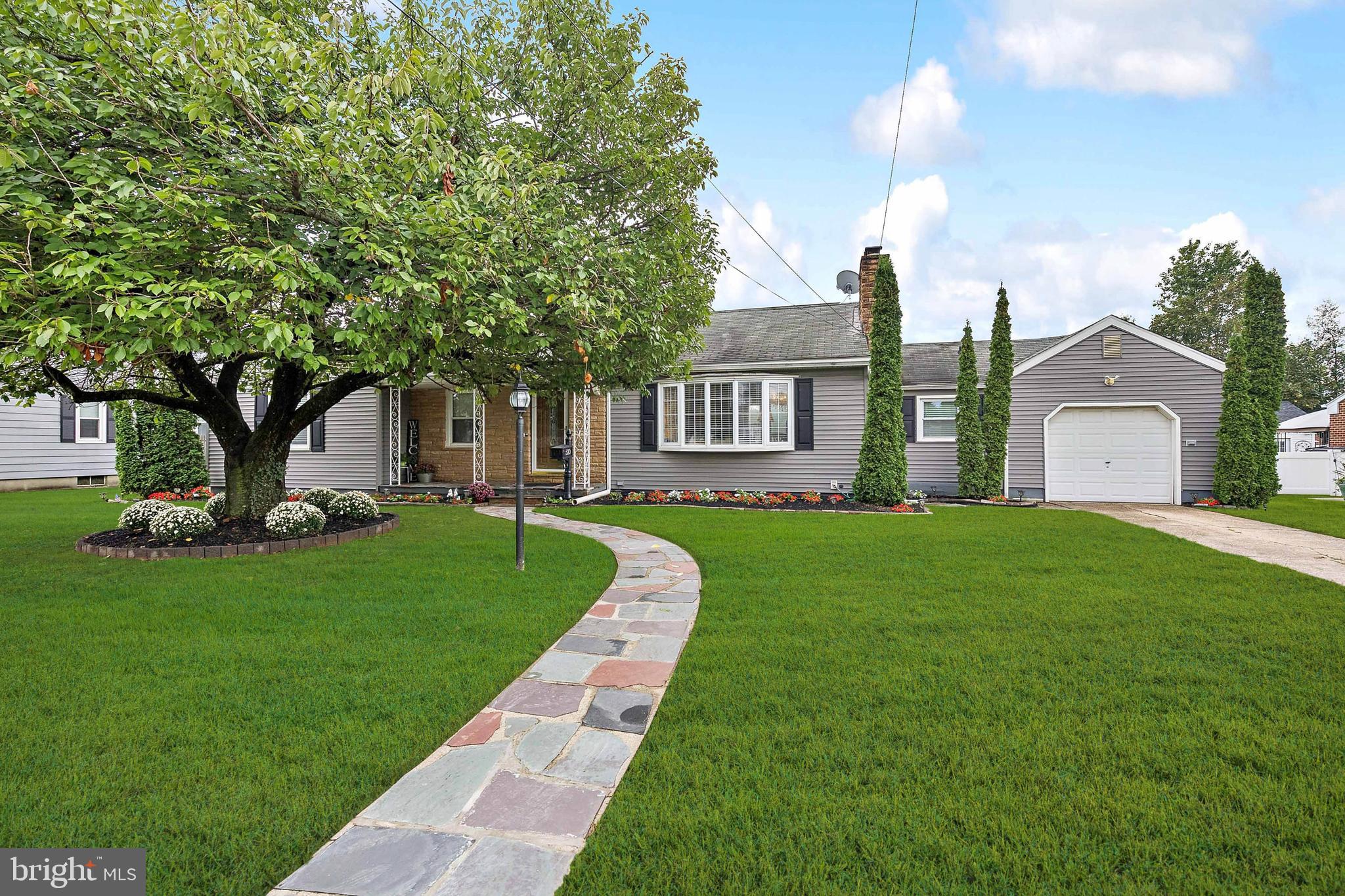 a front view of a house with a garden and yard