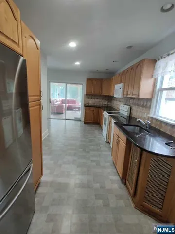 a kitchen with stainless steel appliances granite countertop a refrigerator a sink a stove a microwave and island