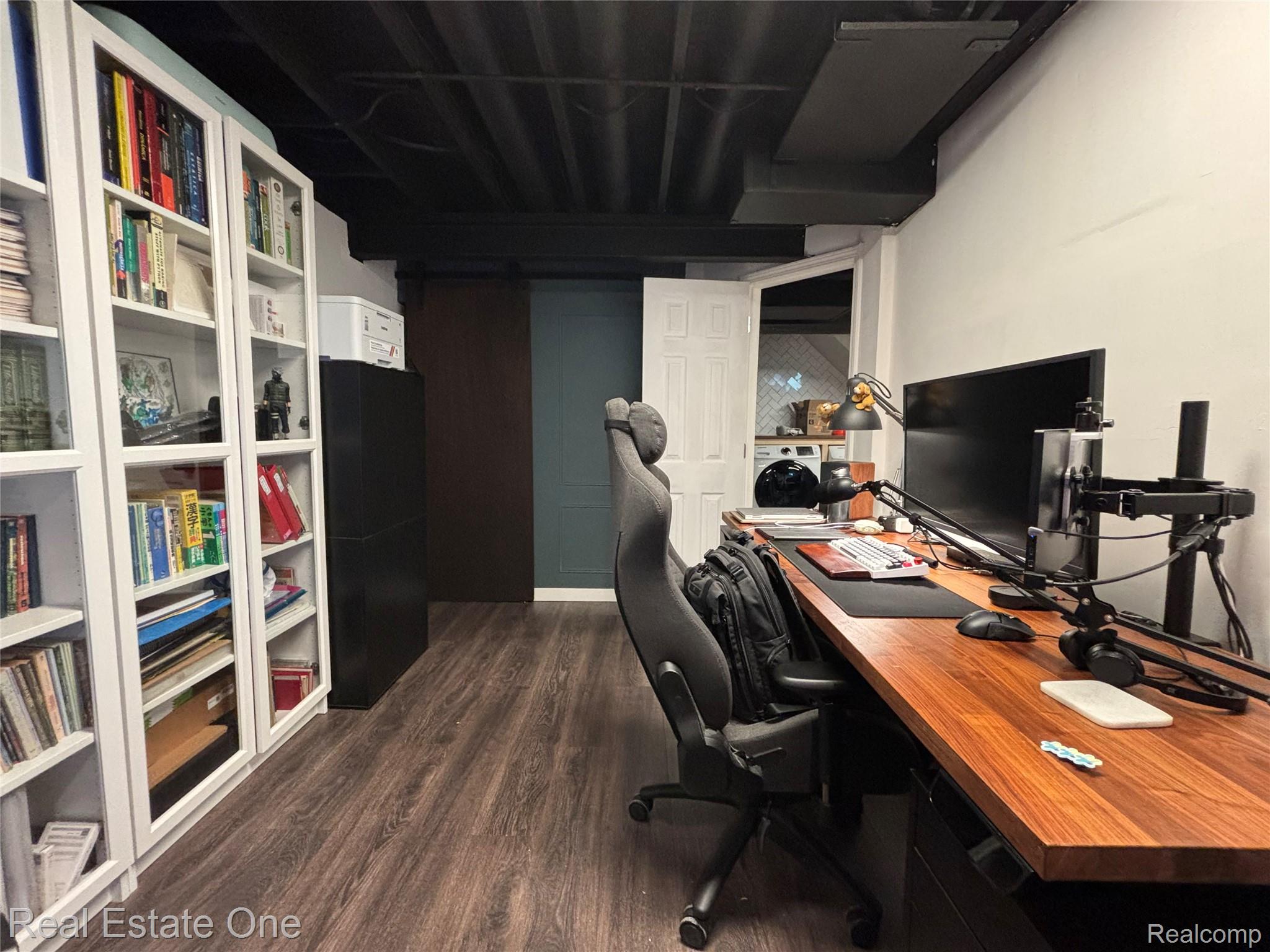 66 Meadow Wood Drive Rochester, MI 48307 - Photo 14 of 20 Dedicated workspace featuring wood-finish flooring, built-in shelving, a wood-top desk, exposed black ceiling joists, and white walls