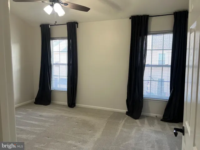 an empty room with windows and closet
