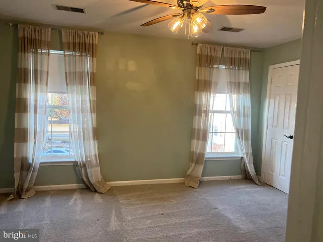 an empty room with windows and closet