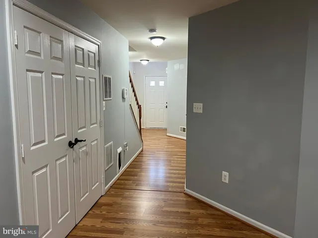 a view of a hallway with wooden floor and staircase