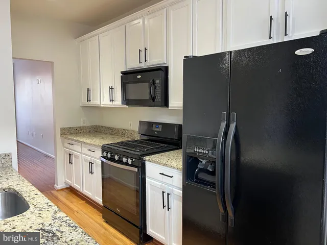 a kitchen with stainless steel appliances granite countertop a refrigerator stove and sink
