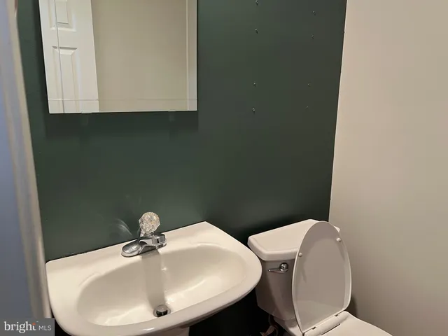 a bathroom with a sink a toilet and mirror