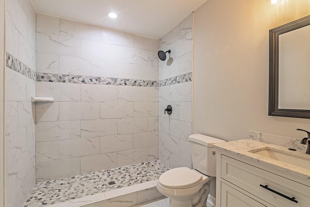 111 Ford Street Cartersville, GA 30120 - Photo 18 of 19 a bathroom with a granite countertop sink a toilet and shower