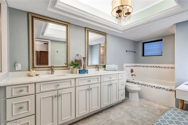 a spacious bathroom with a double vanity sink a mirror and a toilet