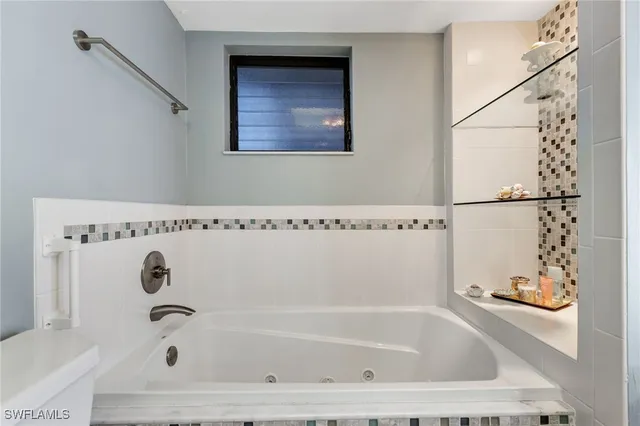 a bathroom with white bath tub and shower
