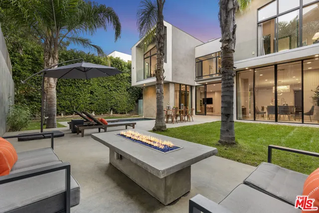 a view of a patio with couches table and chairs and potted plants