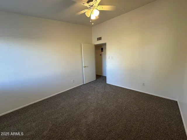 an empty room with a ceiling fan and a window