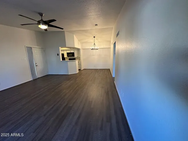 wooden floor in an empty room with a kitchen