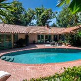 a view of a house with swimming pool and a yard