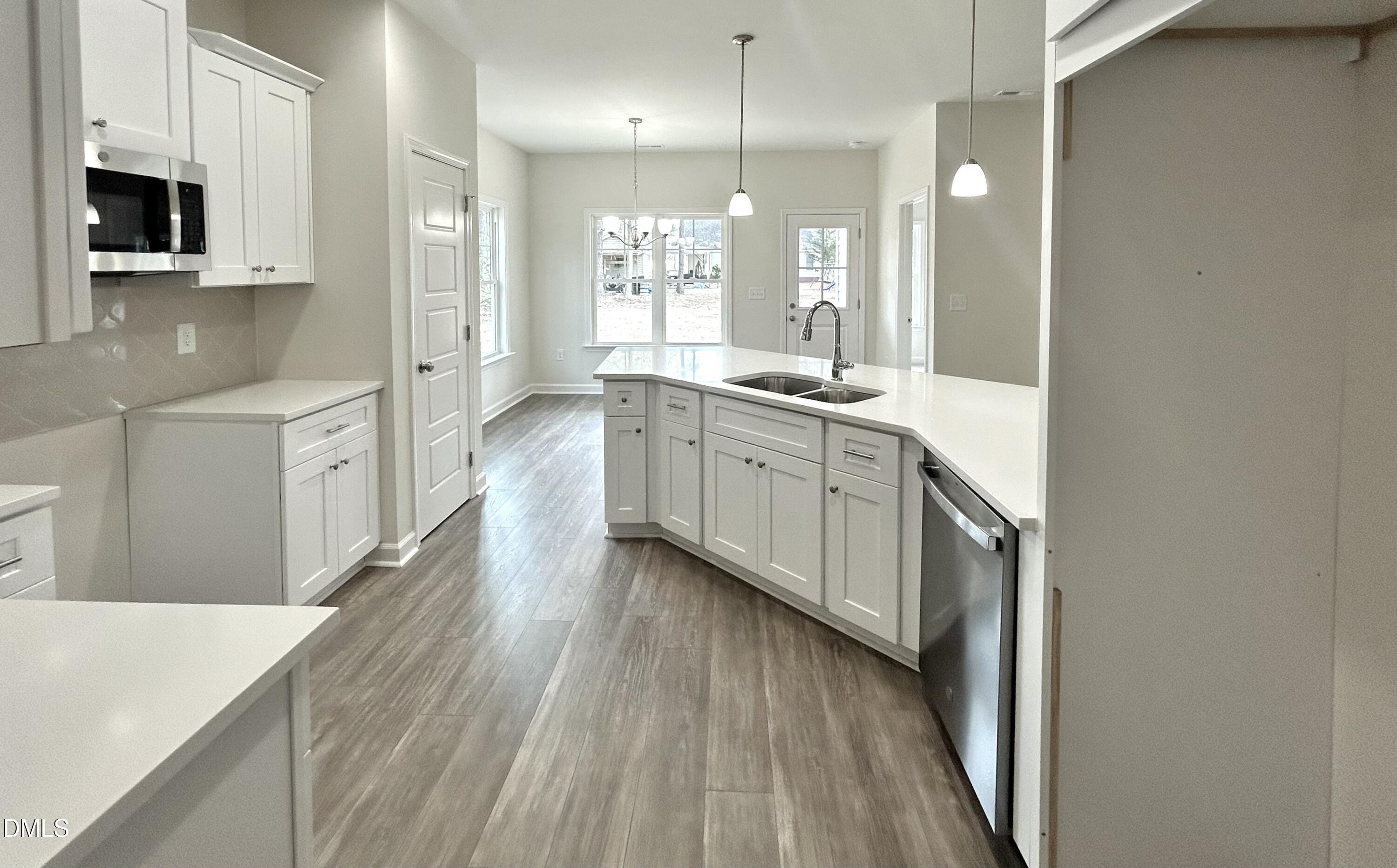 1725 Cardinal Drive Deep Run, NC 28525 - Photo 14 of 21 a large white kitchen with cabinets a sink and dishwasher a stove with wooden floor