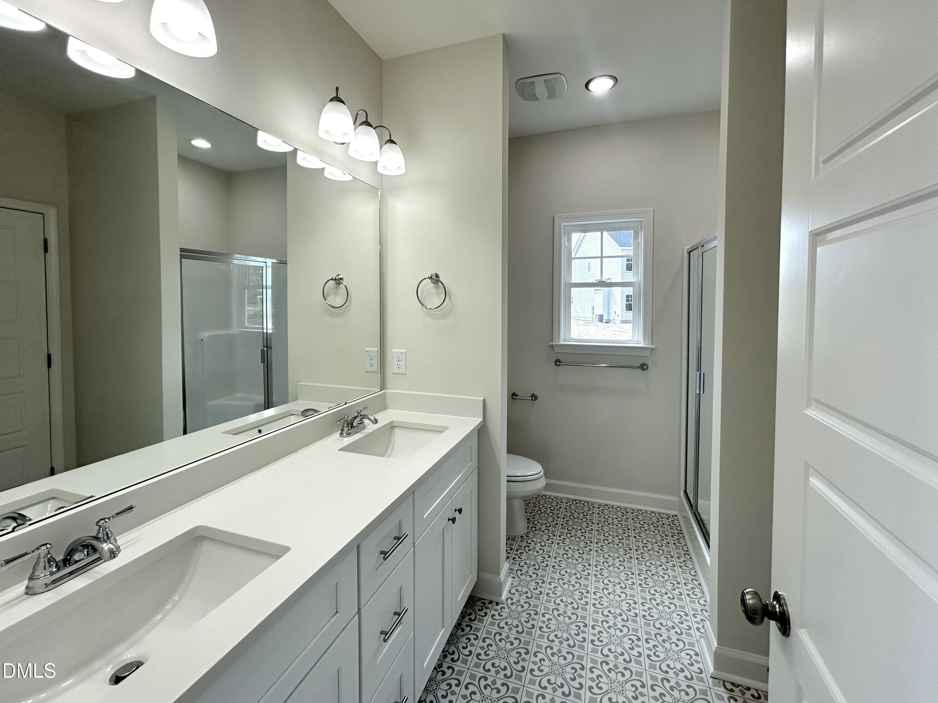 1725 Cardinal Drive Deep Run, NC 28525 - Photo 16 of 21 a spacious bathroom with a double vanity sink a toilet and a mirror