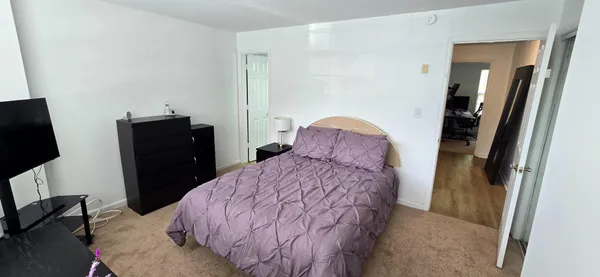 a bedroom with a bed a couch and a large mirror